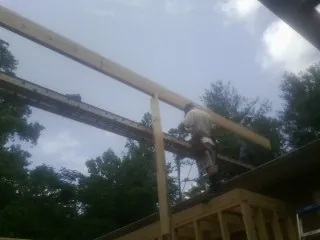 Carpenter setting a ridge beam over a new addition frame — Ice Dam Removal by Roofing Brothers in Powhatan