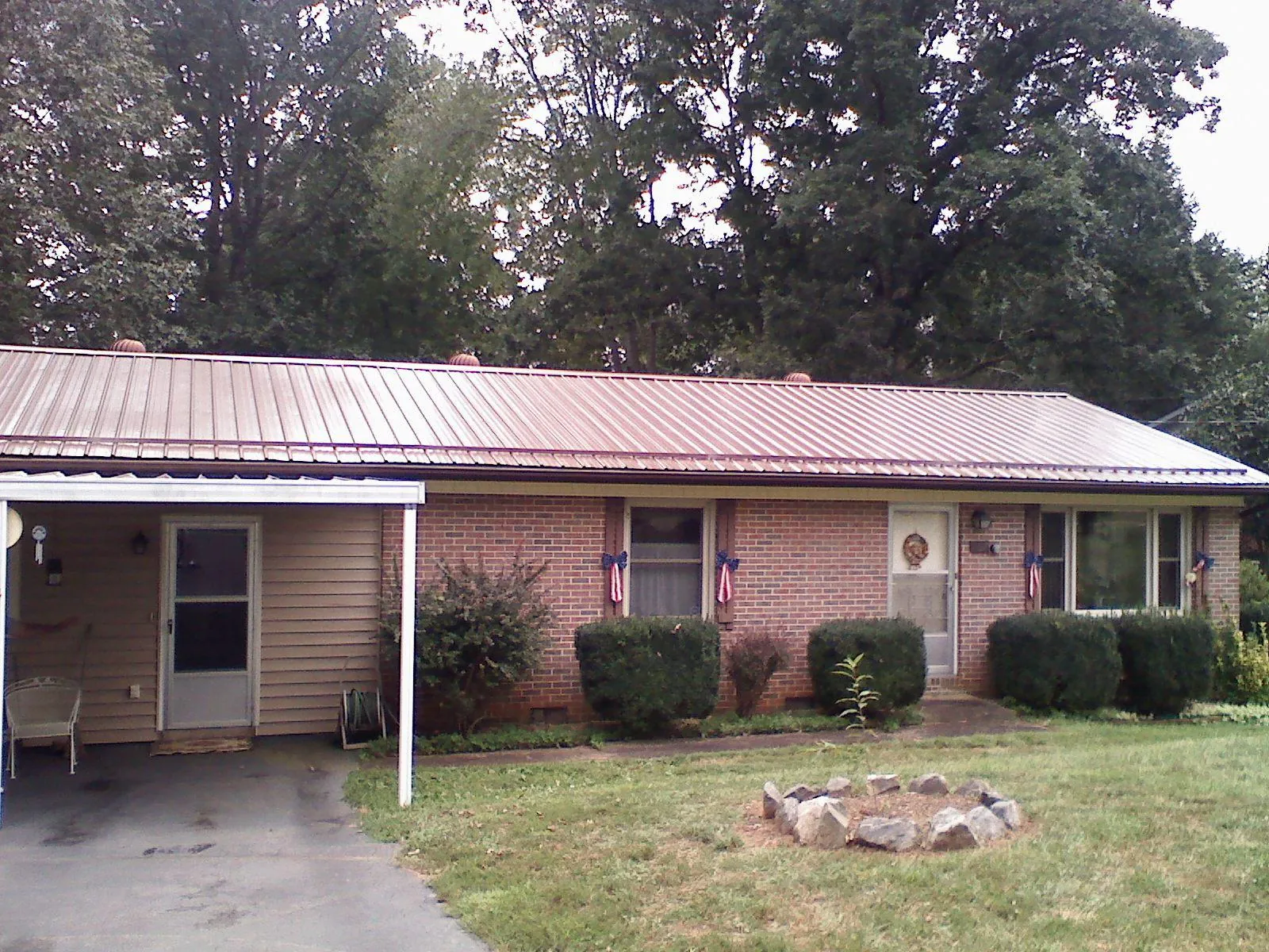 Bronze metal roof and carport on a brick ranch home — Roof Repair work by our crew in Powhatan