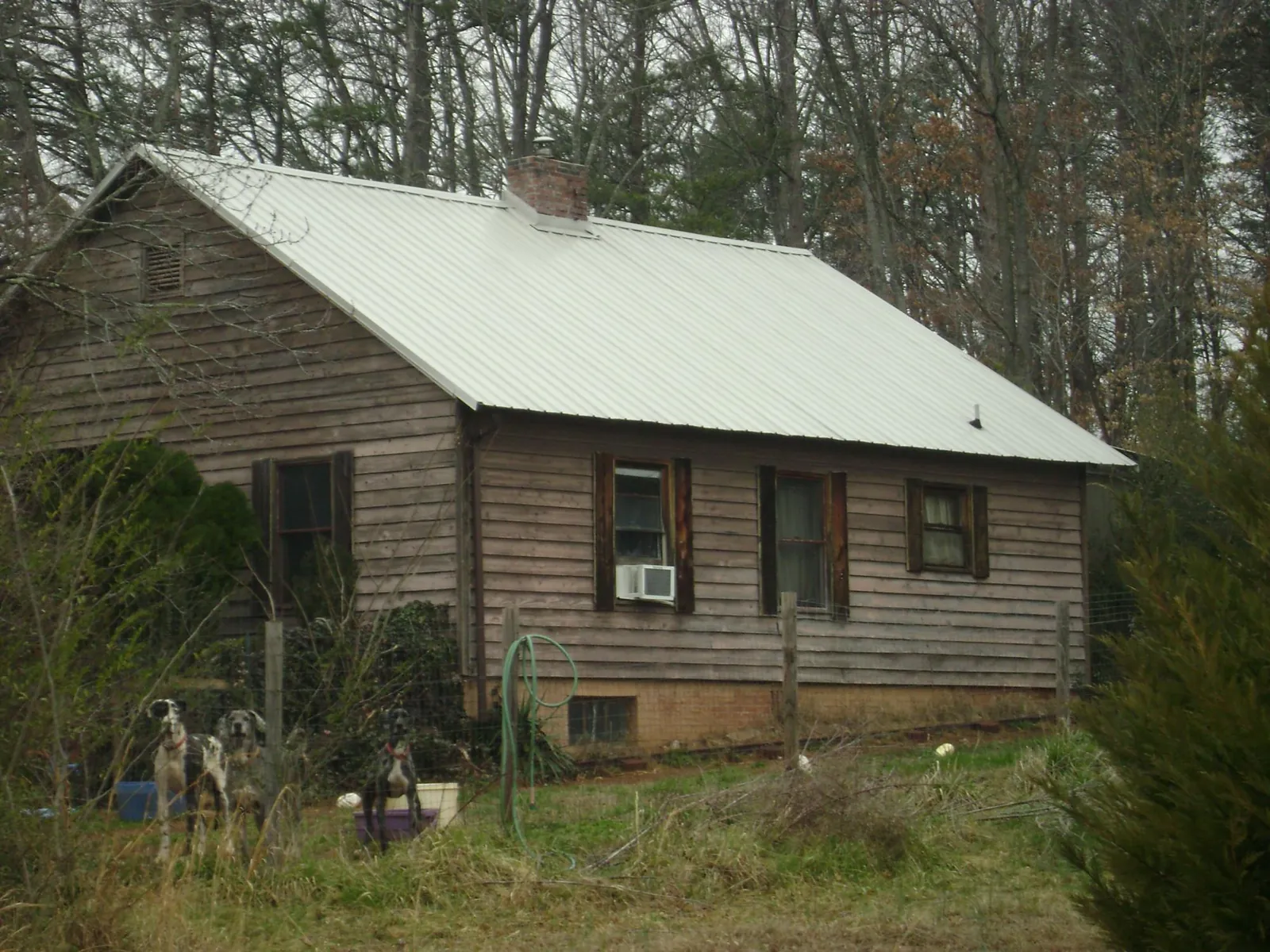 White metal roof on an old wood sided farmhouse, from a Metal Roof Installation job in Powhatan